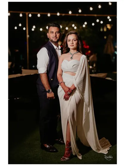 An effortlessly chic look for an intimate sit-down dinner. The bride wears a stunning white structured dress by Amit Aggarwal, paired with a modern necklace, while the groom is classic in a waistcoat.