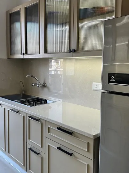 Another angle of the Nirala Estate kitchen, showing the sink area and the ample counter space, illuminated by under-cabinet lighting.