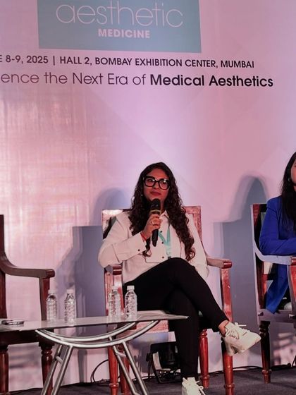 A candid shot while speaking about the nuances of using different types of skin boosters for rejuvenation. I enjoy breaking down complex topics for my peers.