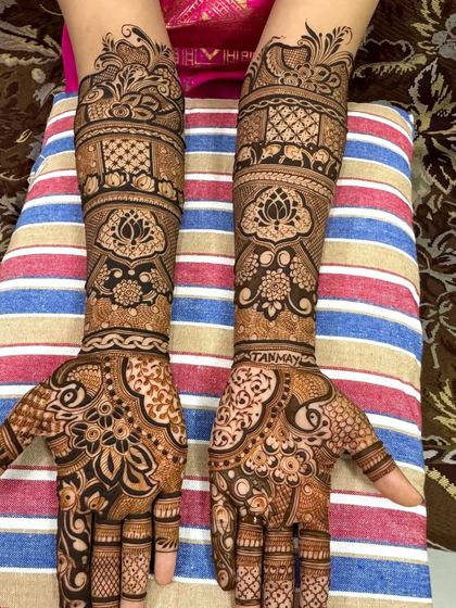 A beautiful lotus-themed bridal design. The name of the groom, Tanmay, is subtly written into the intricate patterns on the palm.