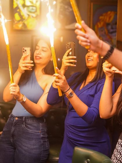 Guests capturing the sparkler moment on their phones.