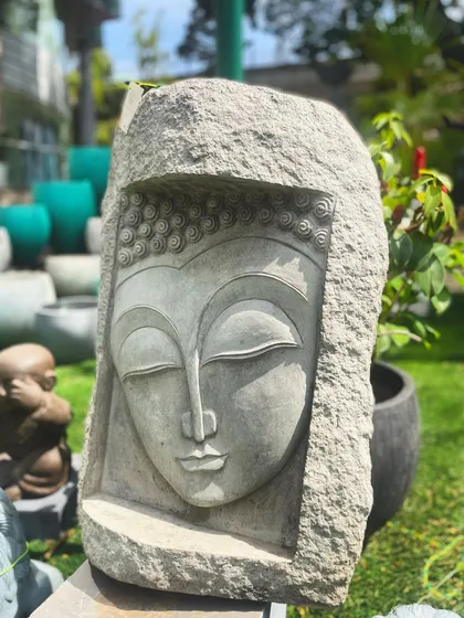 This unique Buddha face mural is carved directly into a rough block of stone. It symbolizes enlightenment and detachment, making it a powerful and artistic statement piece for a wall or garden.