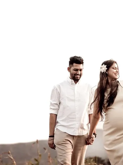 A radiant portrait of the couple walking together at golden hour. The warm light catches her hair and her smile, making the entire scene glow with happiness.