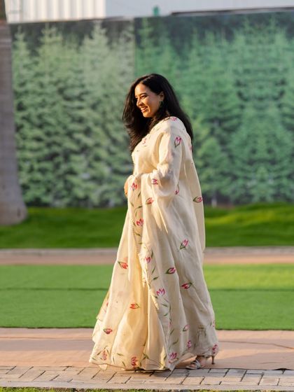 A candid walking shot at an outdoor corporate event. The elegant floral lehenga was perfect for the festive and celebratory atmosphere.