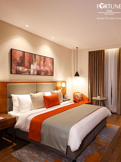 A full view of our luxury room, showcasing the clean, modern design. The combination of wood tones and bright orange creates a welcoming and stylish retreat.