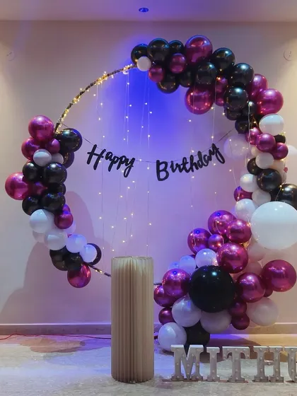 A stylish ring decor setup for a home party. This elegant design uses chrome balloons and fairy lights to create a sophisticated backdrop for any celebration.