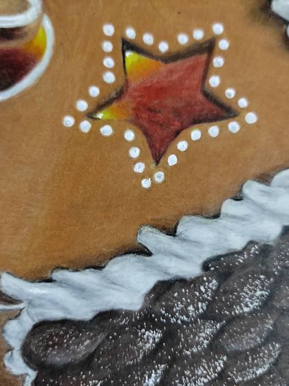 A close-up on the star-shaped window and frosted roof of the gingerbread house.