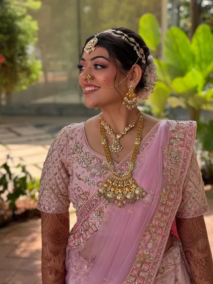 The bride looking absolutely stunning with her floral bun and beautiful pink lehenga. This is a perfect look for a daytime wedding.