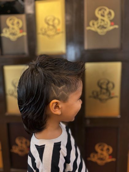 Another angle of the detailed hair design, showcasing the precision work our stylists can do.