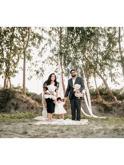 A formal family portrait taken in a beautiful, rustic outdoor location. The family is dressed elegantly, creating a timeless image with a natural backdrop.