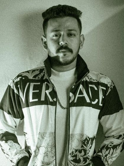 A black and white portrait with a gritty, high-contrast look. This edit emphasizes the model's direct gaze and the bold branding on his jacket, creating a powerful and modern fashion image.