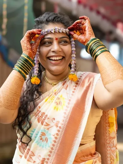 The pure, uninhibited laughter during a Haldi ceremony. I love capturing these candid moments of happiness. The bride's joyful expression as she adjusts her floral jewelry is what makes this wedding ritual so special.