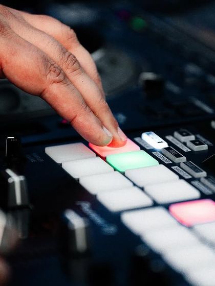 Hitting the pads on my controller to trigger samples and effects. It's a hands-on process of building the music live for the crowd.