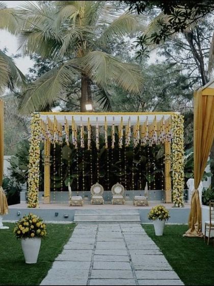 This is the full view of our yellow and white themed outdoor wedding. The aisle leads to a beautifully decorated mandap, flanked by canopies with yellow drapery, creating a bright and cohesive look for the entire ceremony space.