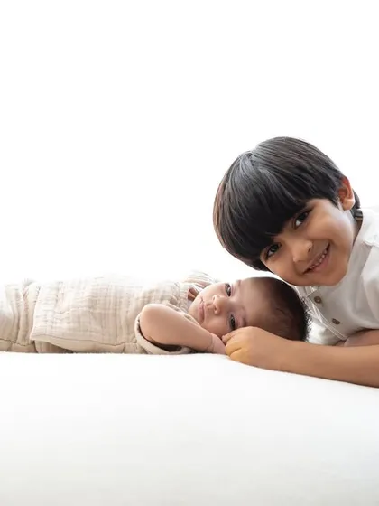 A proud big brother smiling next to his new sibling. Capturing the beginning of this lifelong friendship is one of the most heartwarming parts of my job.