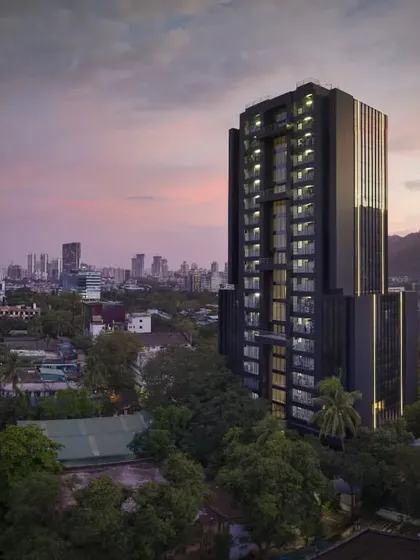 A commercial tower in Thane, designed to be modern, elegant, and sharp. As dusk settles, the building's facade glass blends with the sky, while integrated vertical light strips create a striking ambiance, accentuating its strong presence in the urban landscape.