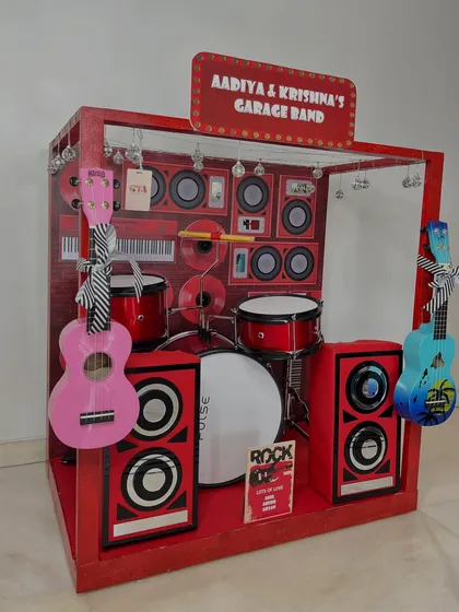 A side view of the 'Garage Band' hamper, showing the hanging guitars and the detailed backdrop of speakers and keyboards that create a mini stage.