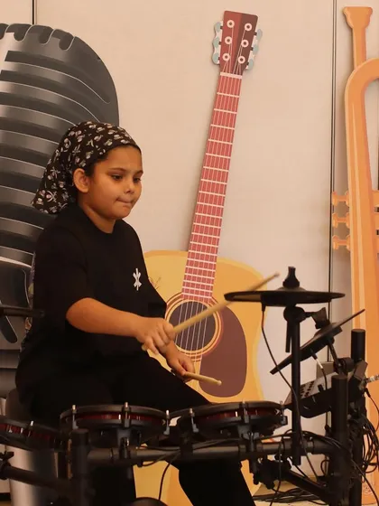 This young drummer is all focus and energy at the Museum of Solutions. Our drum lessons are available for all ages, helping students find their rhythm.