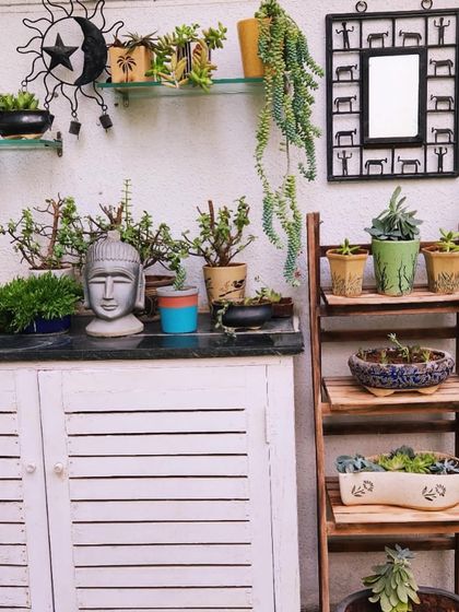 A beautifully styled corner with a Buddha head planter, succulents, and other decor, showing how we integrate personal touches.