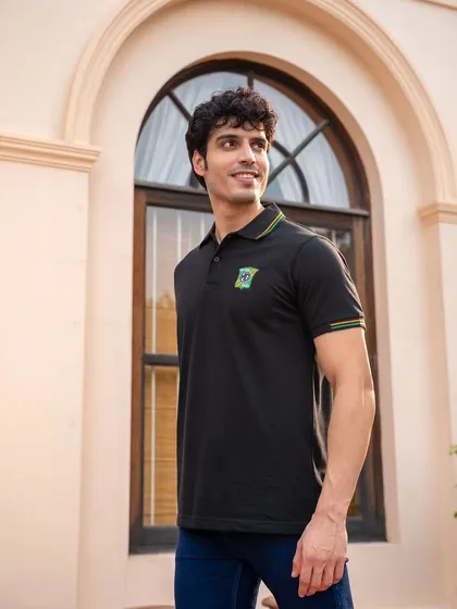 A three-quarter portrait of a model in an MG Motor polo. The natural outdoor lighting and relaxed pose make the apparel feel approachable and perfect for everyday wear.