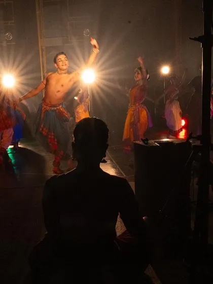 A view from the wings during a performance of 'PADAM'. This perspective shows the complex lighting setup and the artists waiting for their cue, a side of the show the audience rarely sees.