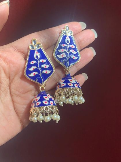 A classic leaf-shaped Meenakari jhumka in a deep royal blue. The intricate white and red floral painting stands out beautifully against the dark base.