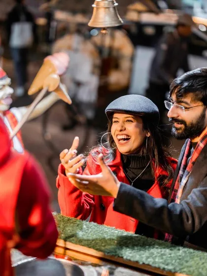 A candid shot capturing a moment of pure fun and laughter. The couple enjoys a playful interaction with a Turkish ice cream vendor, showing that the best memories are often the unscripted ones.