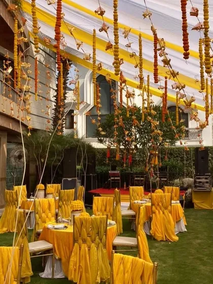An outdoor Mehendi ceremony comes alive with the right decor. We used vibrant yellow drapes and marigold garlands to create a festive canopy, transforming a simple lawn into a bright and cheerful celebration space.