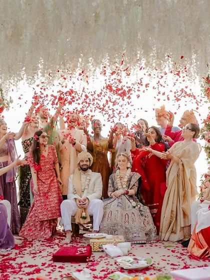 The entire wedding party showering the couple with petals, a moment of collective celebration.