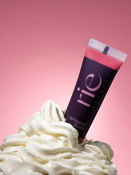We brought the "whipped" product name to life by styling this blush tube in a swirl of actual whipped cream. This playful, conceptual shot makes the product's texture and name instantly memorable.