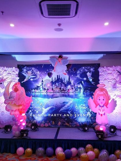An enchanting Fairy Land theme for a birthday, creating a magical atmosphere with large unicorn and fairy cutouts, and dramatic purple stage lighting.