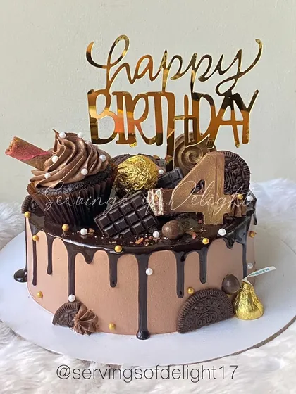 For the ultimate chocolate lover, this is my Chocolate Overload drip cake. It's a rich chocolate cake topped with more chocolate, including Ferrero Rocher, Oreos, chocolate bars, and a whole cupcake.