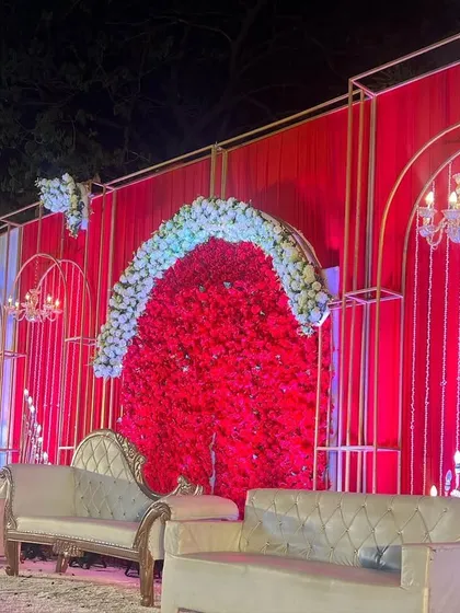 For clients who love bold statements, I designed this stunning all-red wedding stage. The combination of a dense red floral backdrop, elegant white seating, and modern gold frames creates a look of pure opulence.