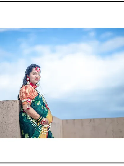 A serene portrait against a backdrop of clouds, highlighting the beauty of the mom-to-be in her traditional attire.