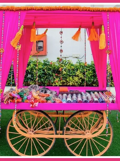 A traditional cart, draped in pink fabric and filled with bangles and other favors for guests, was a beautiful and functional part of the mela decor.