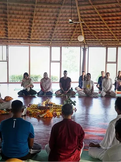 Students and teachers gather in a circle for a Puja ceremony in our main yoga shala. This ritual of reverence helps to purify the space and focus the mind.