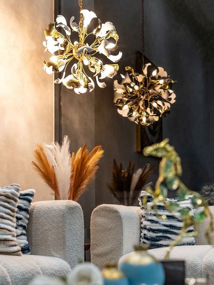 Two floral-inspired chandeliers installed in a client's home, adding a touch of sculptural art and warm light to the living space.
