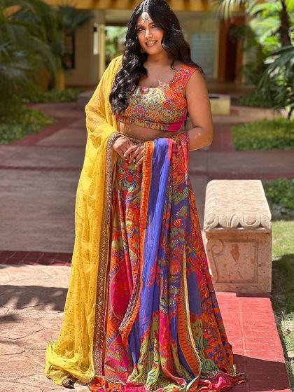 A full-length shot of our client, showing how the single statement teeka completes her colourful lehenga look.