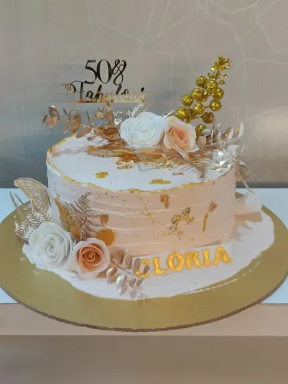 "50 & Fabulous" indeed. This peach-toned cake is decorated with white and peach sugar roses, delicate gold leaves, and shimmering gold dust for a glamorous and celebratory feel.