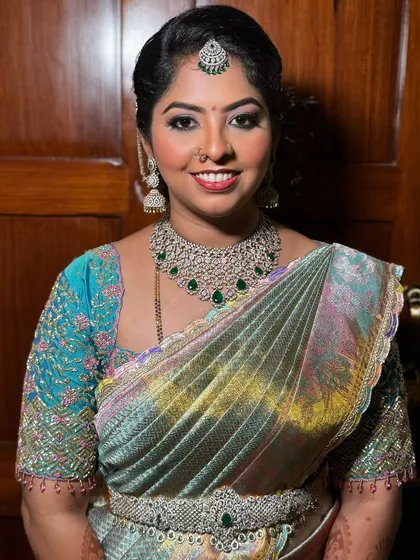A happy client portrait. Ashritha is glowing, and the saree drape perfectly complements her diamond jewelry and elegant makeup, making her shine at the family function.
