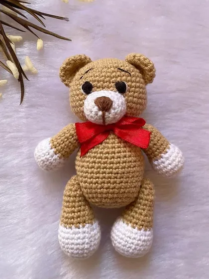 A classic teddy bear, a timeless gift for any age. This one is shown with a red ribbon, a black tie for 'Daddy Bear', and with expressive green eyes. They are soft, cuddly, and made to be loved.