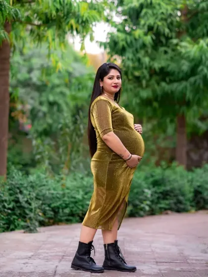 A modern and stylish outdoor portrait. The mom to be's fitted dress and boots show that maternity fashion can be whatever you want it to be.