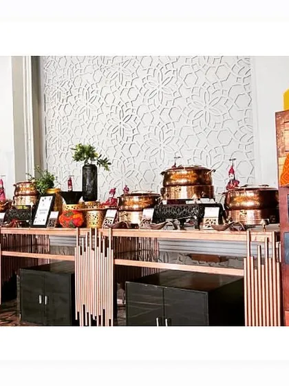 A Rajasthani-themed buffet counter, decorated with traditional puppets and colourful elements to create a festive atmosphere.