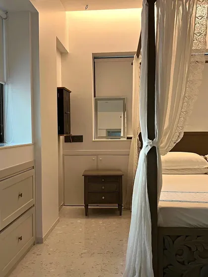 In this bedroom, a carved four-poster bed with delicate curtains serves as the centerpiece. The design translates the Bohemian ethos into a serene space filled with texture and a relaxed, artistic vibe.