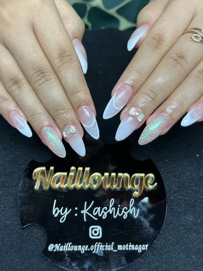 A classic white ombre stiletto set with a subtle glitter effect and 3D rhinestone bows.