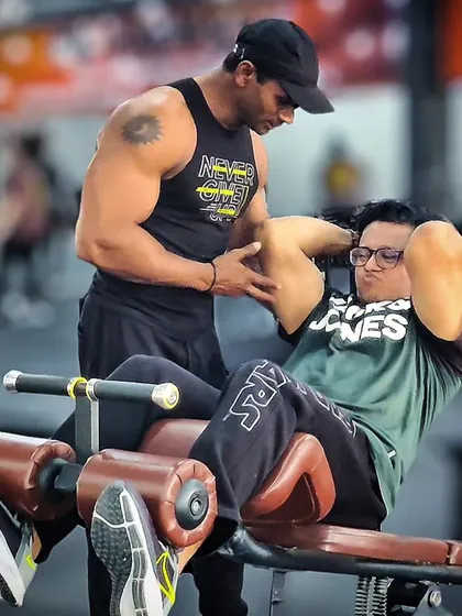 Abs workout mein form correction. Main client ko guide kar raha hoon taaki woh apne core ko theek se engage kare aur lower back pe strain na aaye.