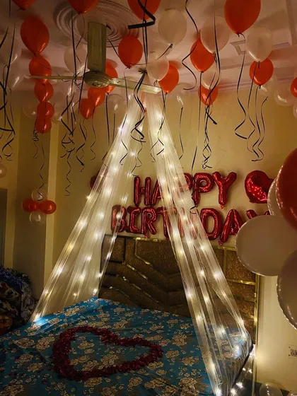 This image captures the magical ambiance created by the combination of the fairy light canopy and the floating balloons with spiraling ribbons.