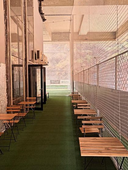 This is my Parents' Pavilion. I've set up this dedicated space with tables and chairs right next to the courts, so parents can watch their kids train, catch up on work, or simply relax.