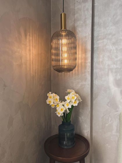 A ribbed glass pendant light in a client's home. The texture of the glass creates a warm, inviting pattern on the wall.