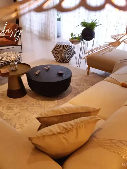 A classy and eclectic living room with a mix of patterns, textures, and unique furniture pieces that come together to create a sophisticated and layered interior.